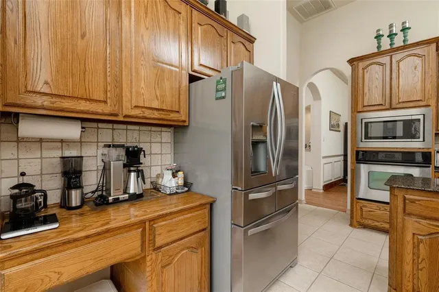 a kitchen with stainless steel appliances granite countertop a refrigerator and a stove top oven