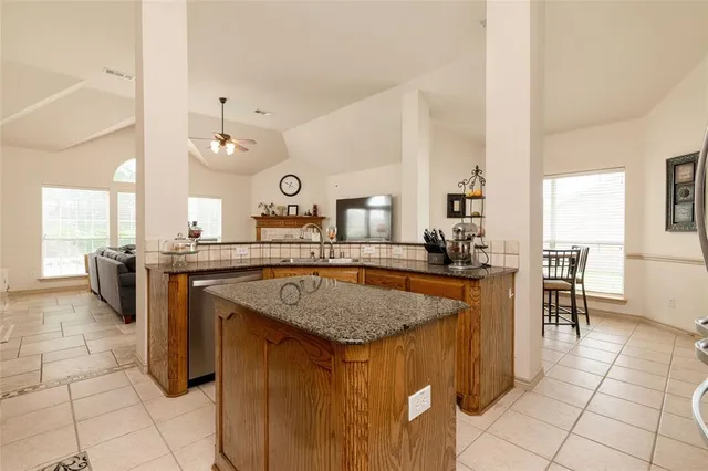 a kitchen with a sink a counter and chairs