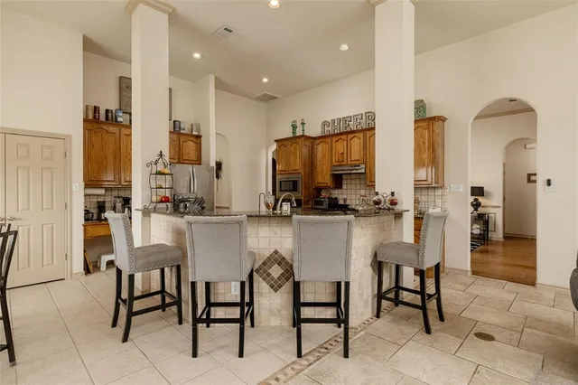 a kitchen with stainless steel appliances kitchen island granite countertop a table and chairs