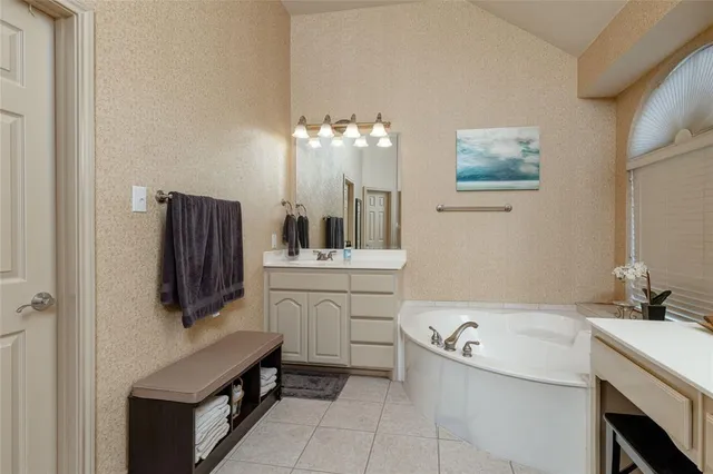 a bathroom with a tub sink and mirror