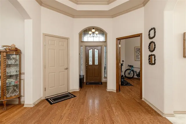 wooden floor in an entryway with a mirror