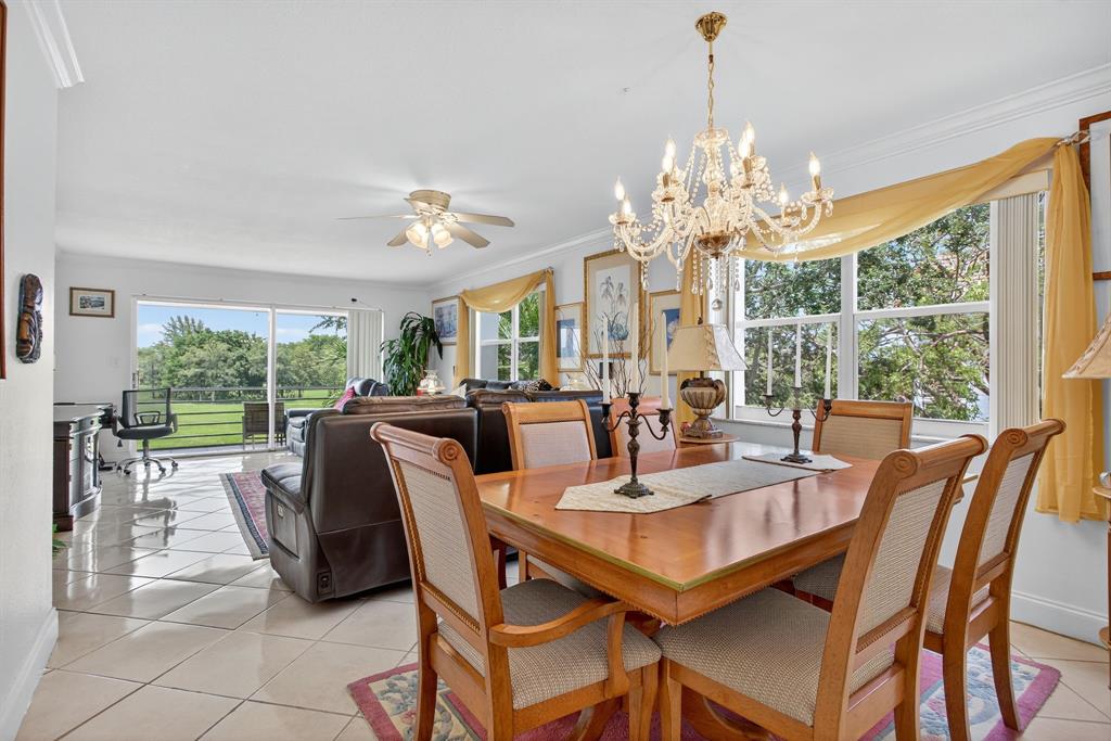 3551 Inverrary Drive, Unit 312 Lauderhill, FL 33319 - Photo 11 of 42 a view of a dining room with furniture a chandelier and large windows
