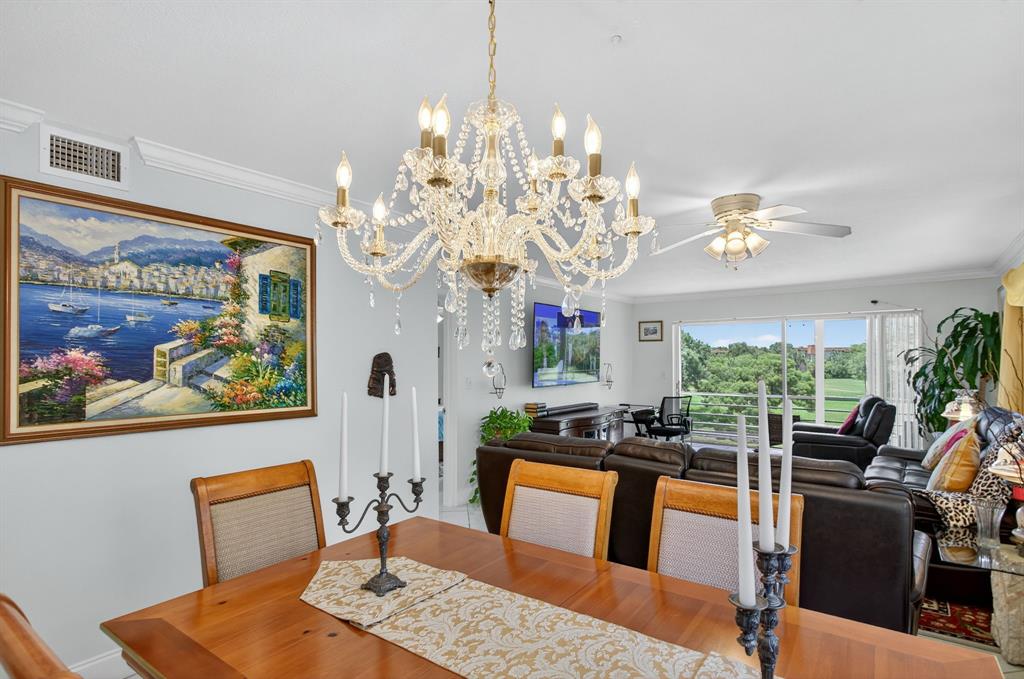 3551 Inverrary Drive, Unit 312 Lauderhill, FL 33319 - Photo 12 of 42 a view of a dining room with furniture a chandelier and wooden floor