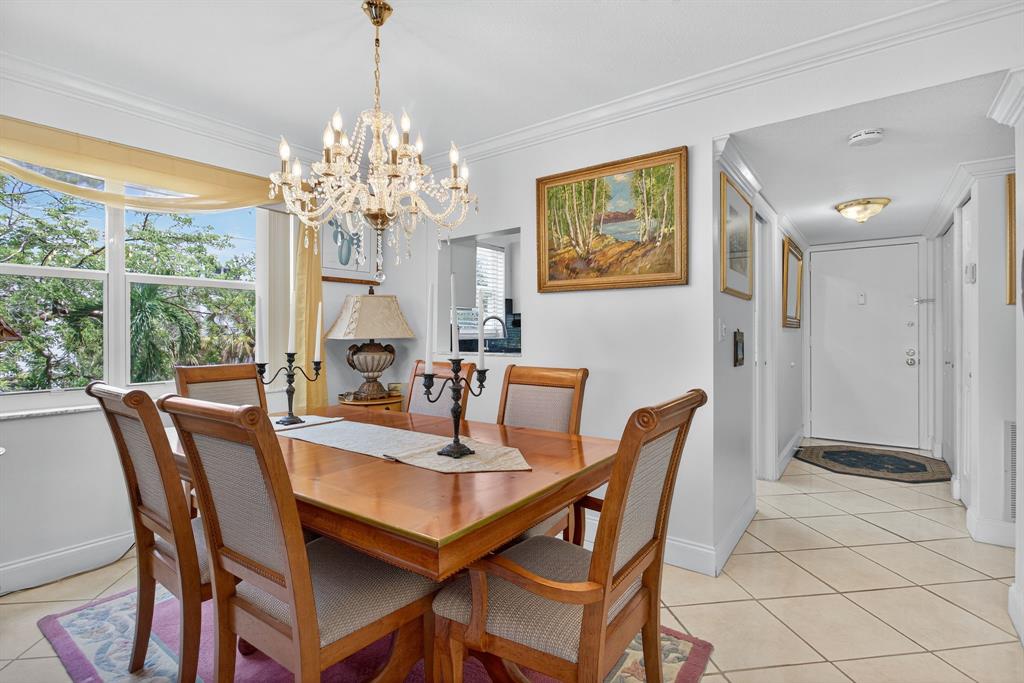 3551 Inverrary Drive, Unit 312 Lauderhill, FL 33319 - Photo 13 of 42 a view of a dining room with furniture a chandelier and large windows