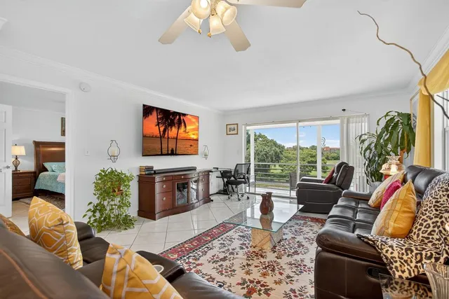 a living room with furniture flat screen tv and a large window