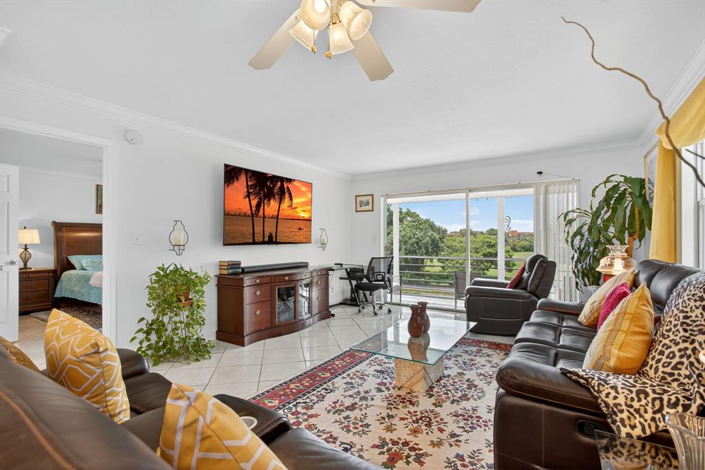 3551 Inverrary Drive, Unit 312 Lauderhill, FL 33319 - Photo 14 of 42 a living room with furniture flat screen tv and a large window