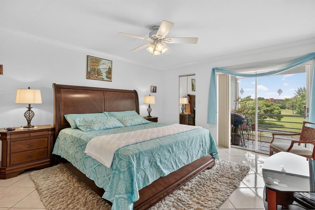 3551 Inverrary Drive, Unit 312 Lauderhill, FL 33319 - Photo 22 of 42 a bedroom with a large bed and a chandelier