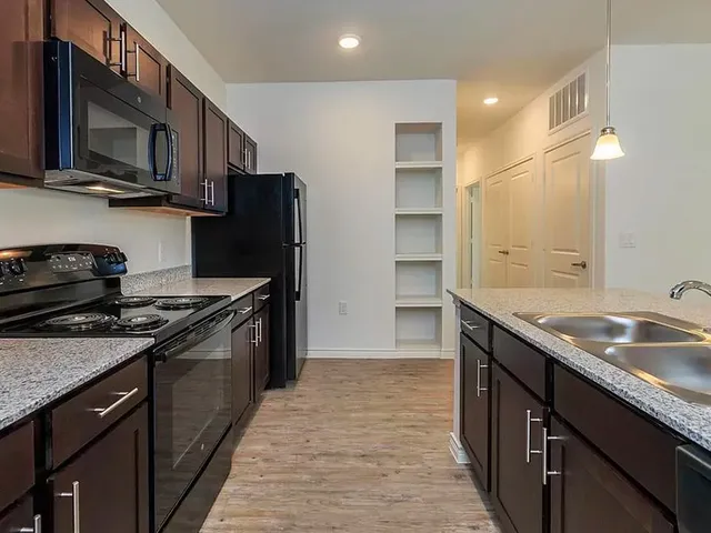 a kitchen with stainless steel appliances granite countertop a sink stove and refrigerator