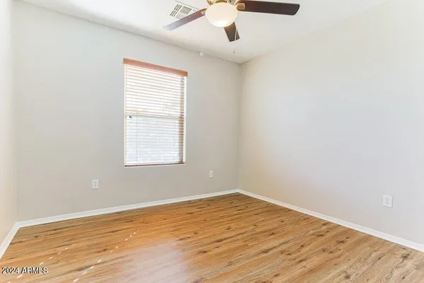 an empty room with a window and ceiling fan