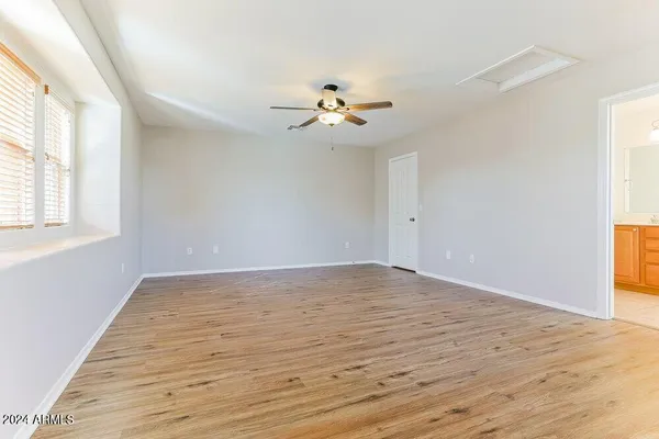 an empty room with windows and fan