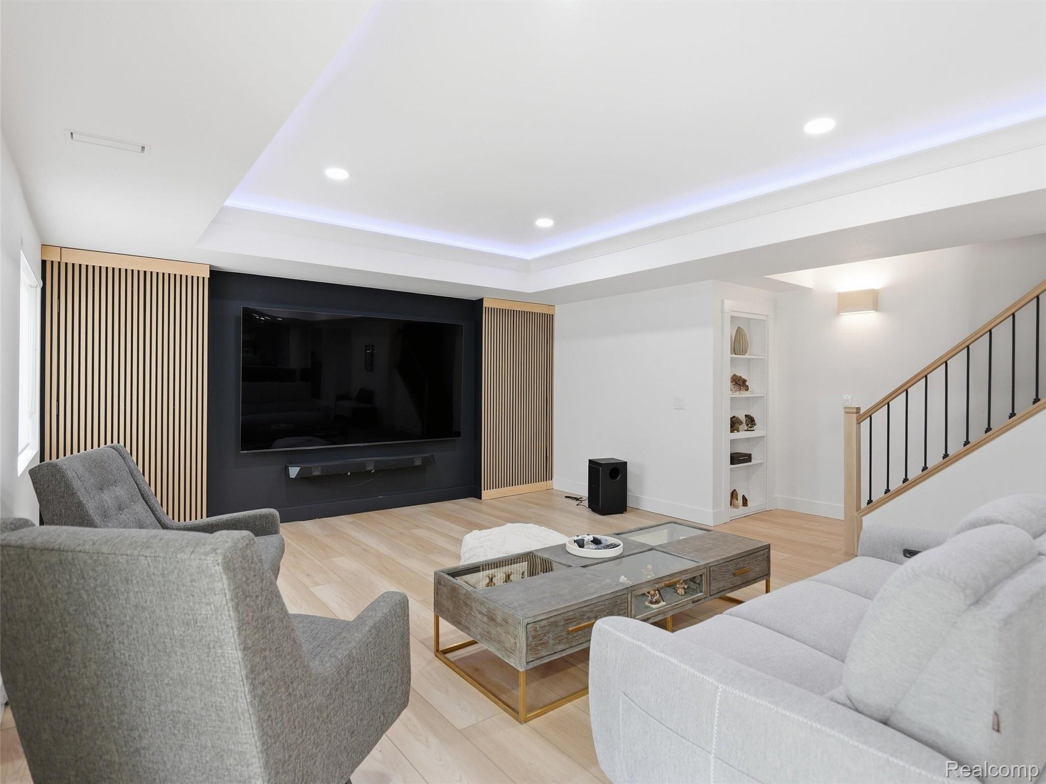 3007 28 Mile Road Washington, MI 48094 - Photo 42 of 69 Modern living area featuring recessed lighting, light wood-finish flooring, a contemporary staircase with iron balusters, built-in shelving, and a feature wall with wood slat accents