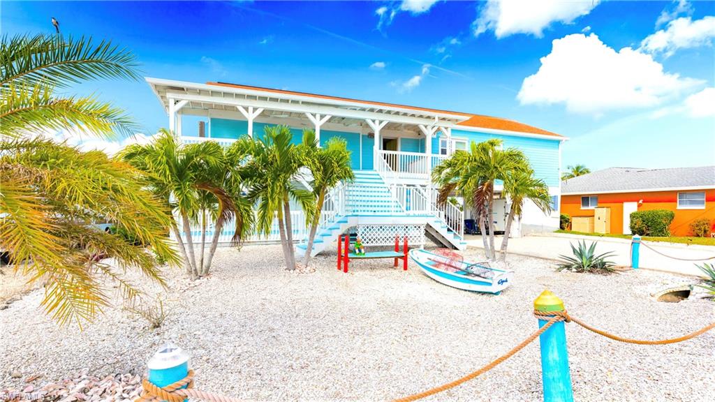 12277 Boat Shell Drive Matlacha Isles, FL 33991 - Photo 7 of 46 a view of a swimming pool with a lounge chair and palm trees