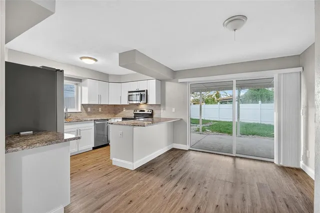 a living room with furniture and a flat screen tv with wooden floor