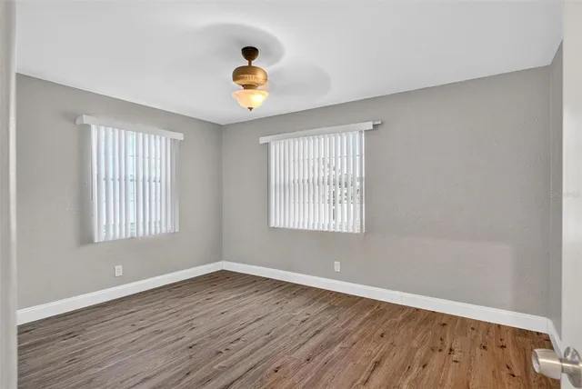 a view of empty room with wooden floor