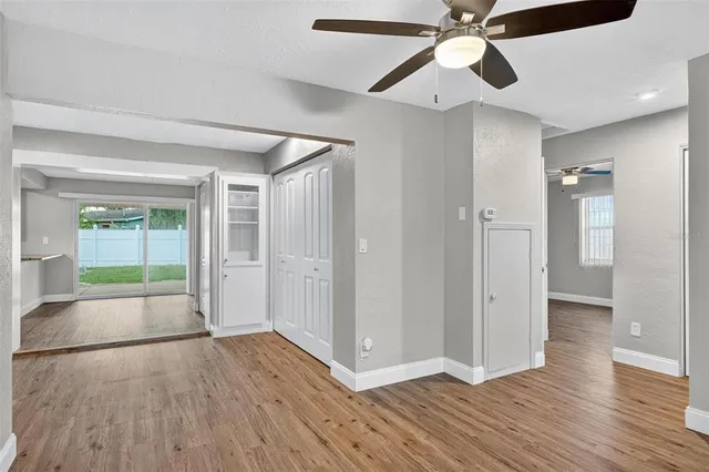 a view of an empty room with wooden floor and a window