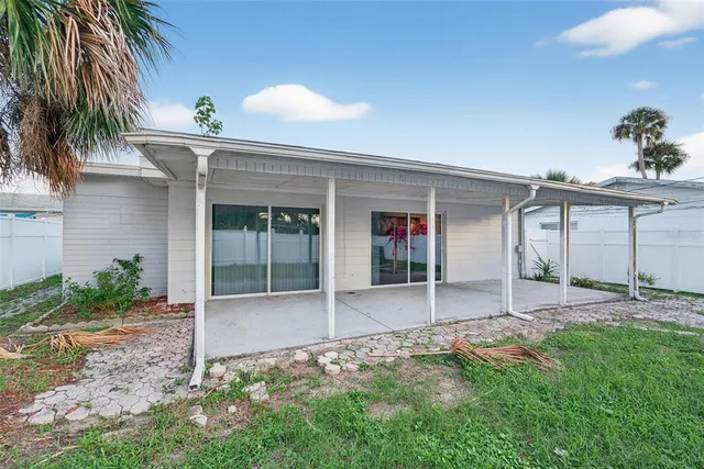 a view of a house with a yard and potted plants