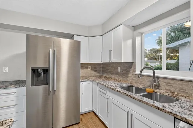 a kitchen with stainless steel appliances granite countertop a refrigerator and a sink