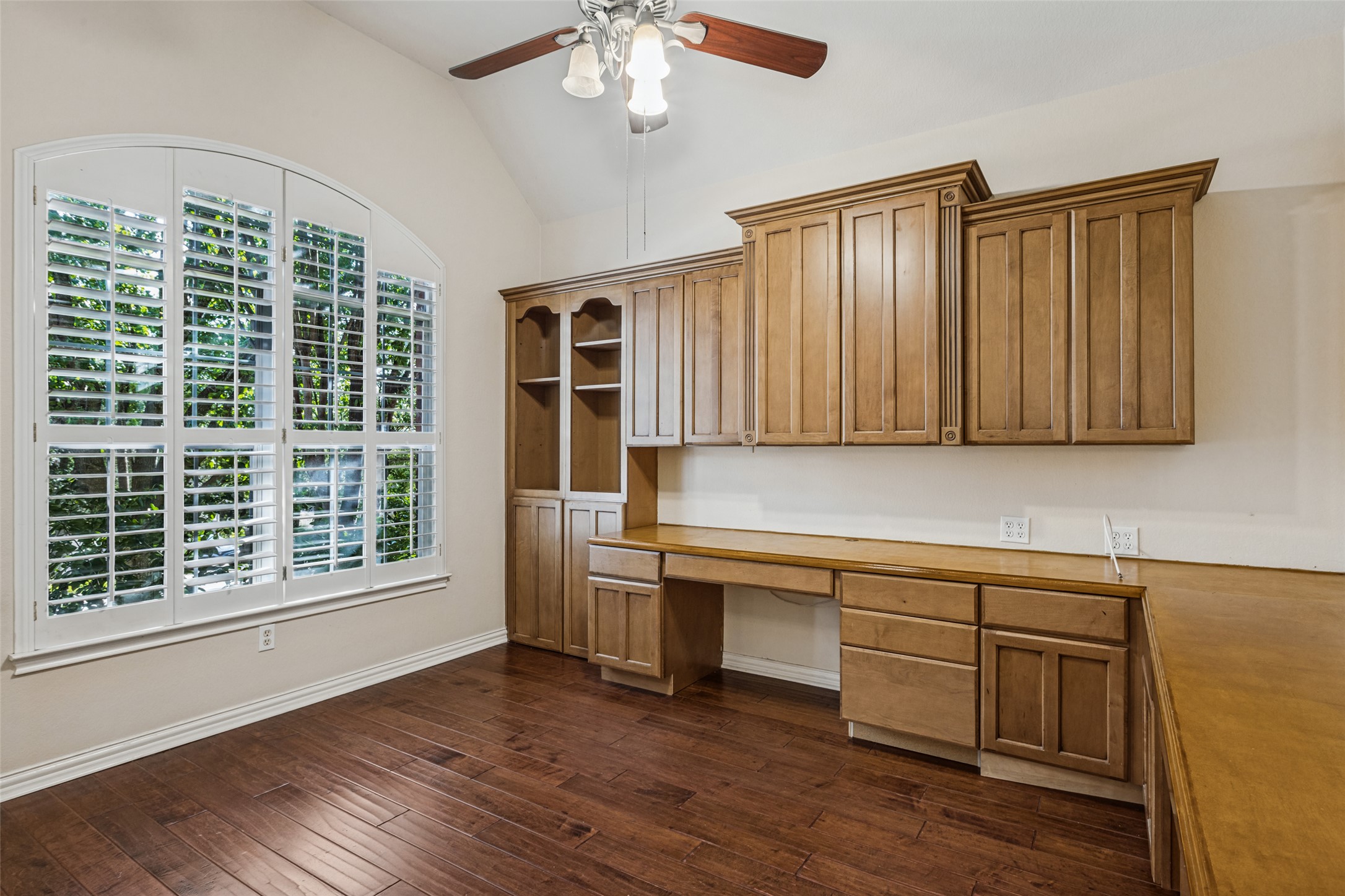 2832 Grimes Ranch Road Austin, TX 78732 - Photo 4 of 23 Rich hardwood flooring complements custom built-in cabinetry beneath a vaulted ceiling.