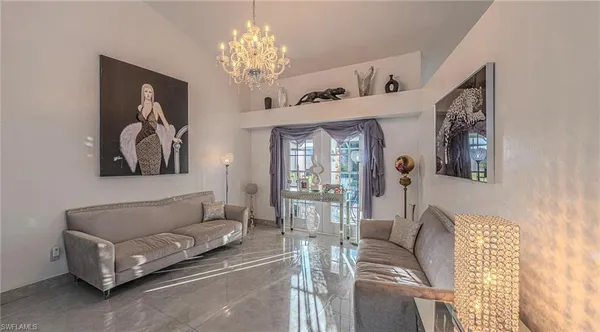 a living room with furniture a chandelier and a painting