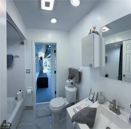 a bathroom with a tub sink and mirror