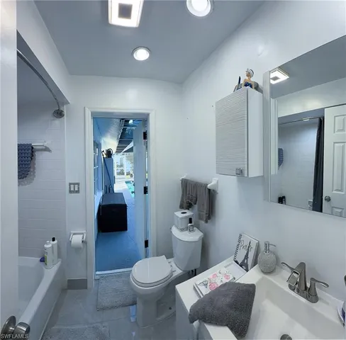 a bathroom with a tub sink and mirror