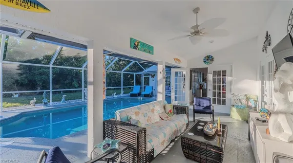 a living room with furniture a chandelier and a floor to ceiling window