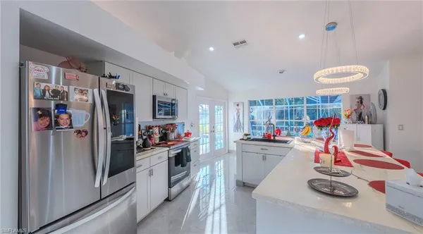 a kitchen that has a lot of cabinets a washer and dryer