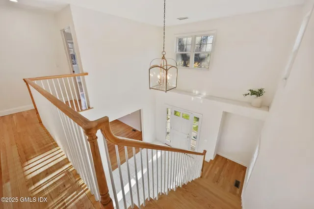 a view of staircase with railing and white walls