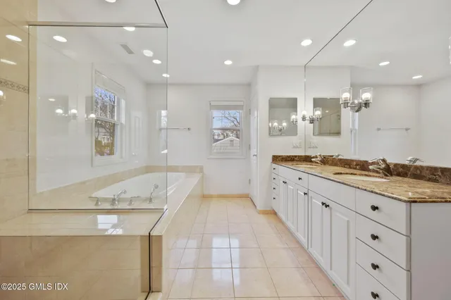 a large bathroom with a granite countertop sink a large mirror and shower