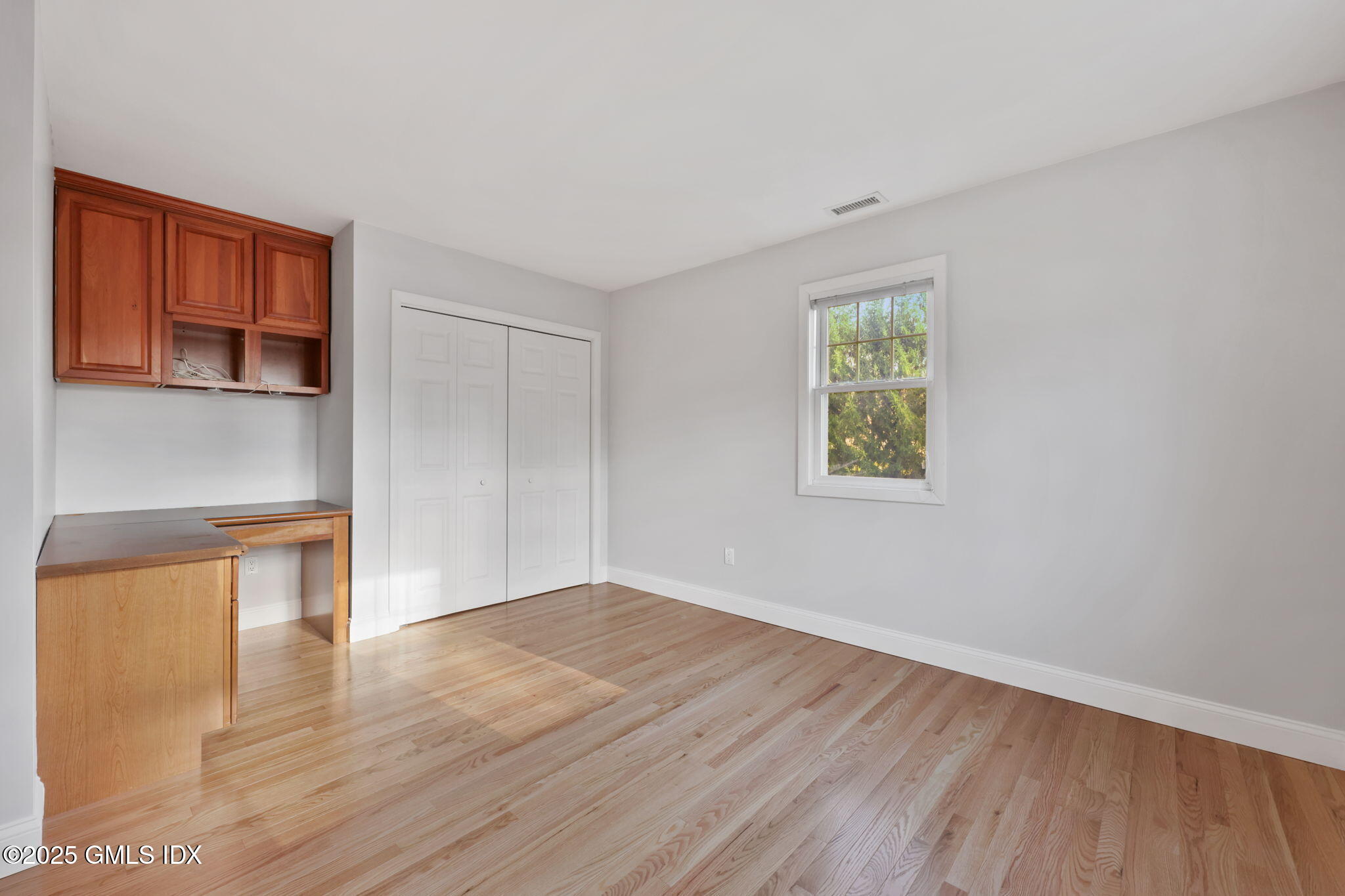 53 Midbrook Lane Old Greenwich, CT 06870 - Photo 22 of 39 a view of an empty room with wooden floor and a window