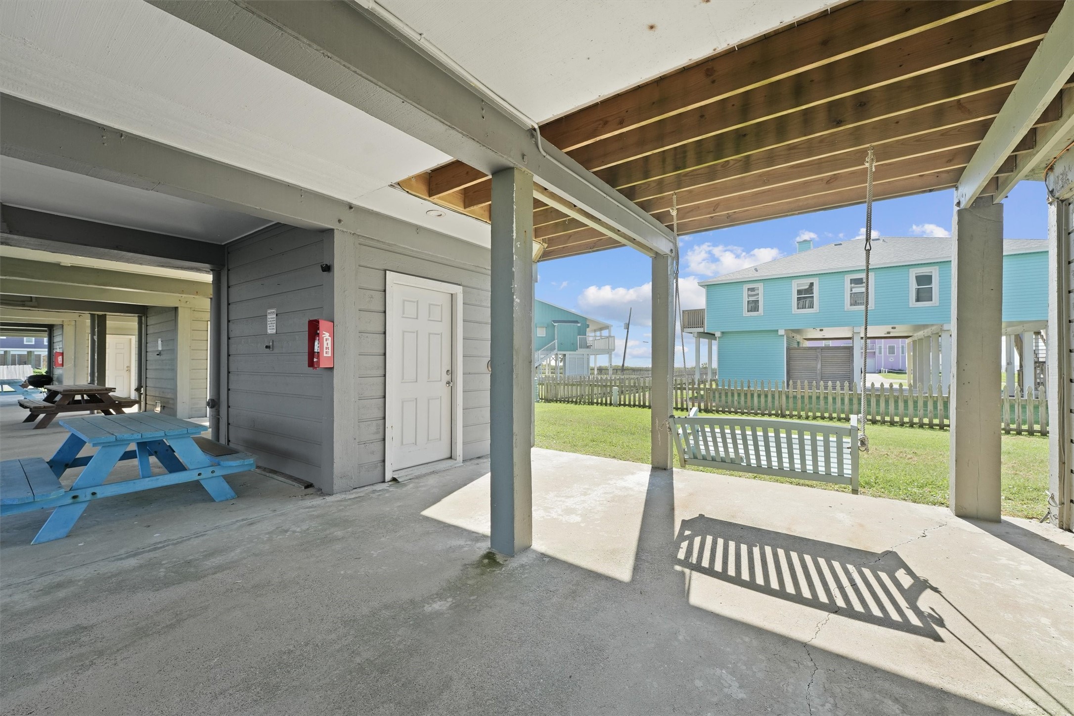 17607 Termini-San Luis Pass Road Galveston, TX 77554 - Photo 35 of 42 The covered patio area is equipped with a swing and a picnic table, making it a perfect place to relax after a day at the beach. The storage room adds extra convenience for keeping outdoor gear secure and organized.