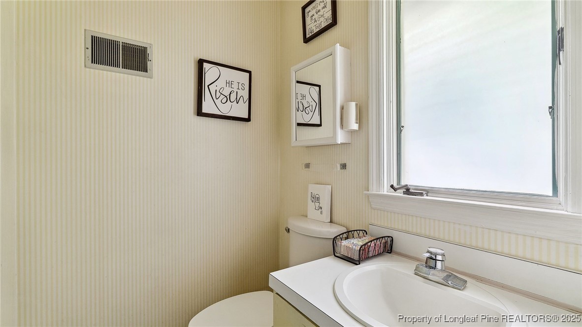 1855 Riverside Boulevard Lumberton, NC 28358 - Photo 26 of 50 a bathroom with a toilet sink and mirror