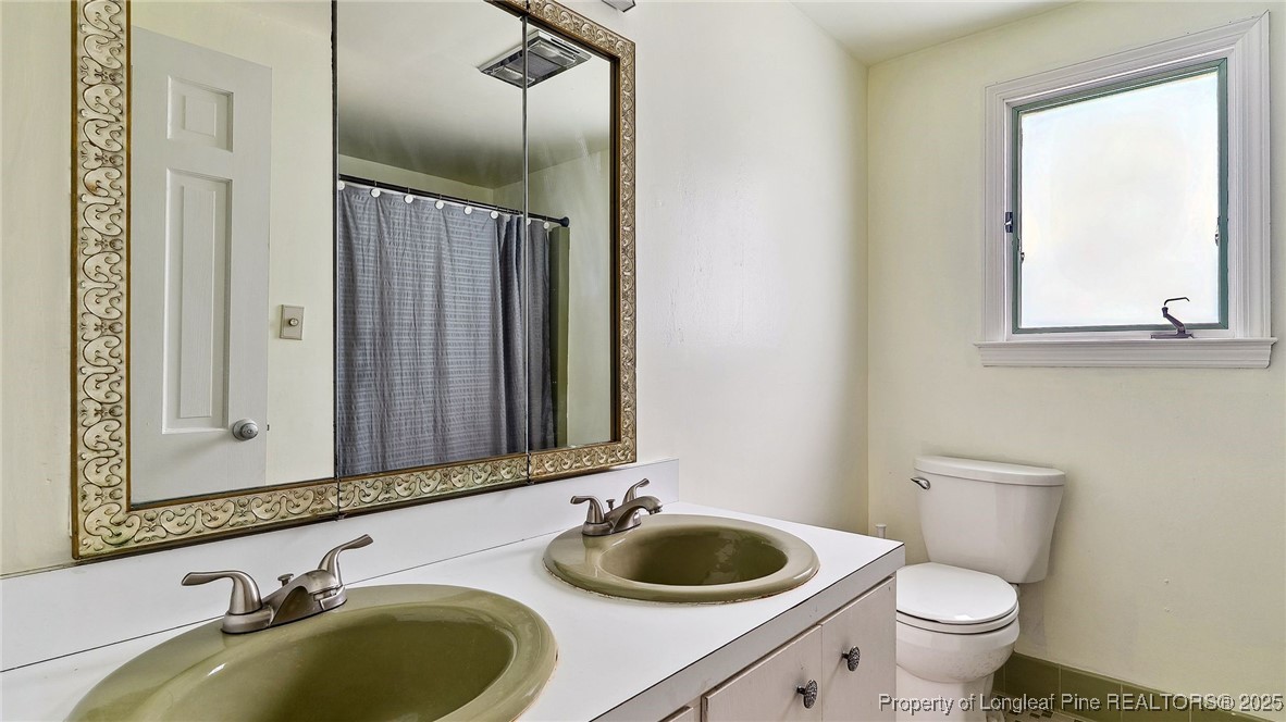 1855 Riverside Boulevard Lumberton, NC 28358 - Photo 33 of 50 a bathroom with a granite countertop toilet sink and mirror
