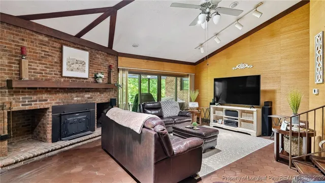 a living room with fireplace furniture and a large window