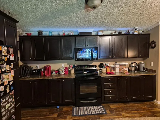 a kitchen with granite countertop a stove and cabinets
