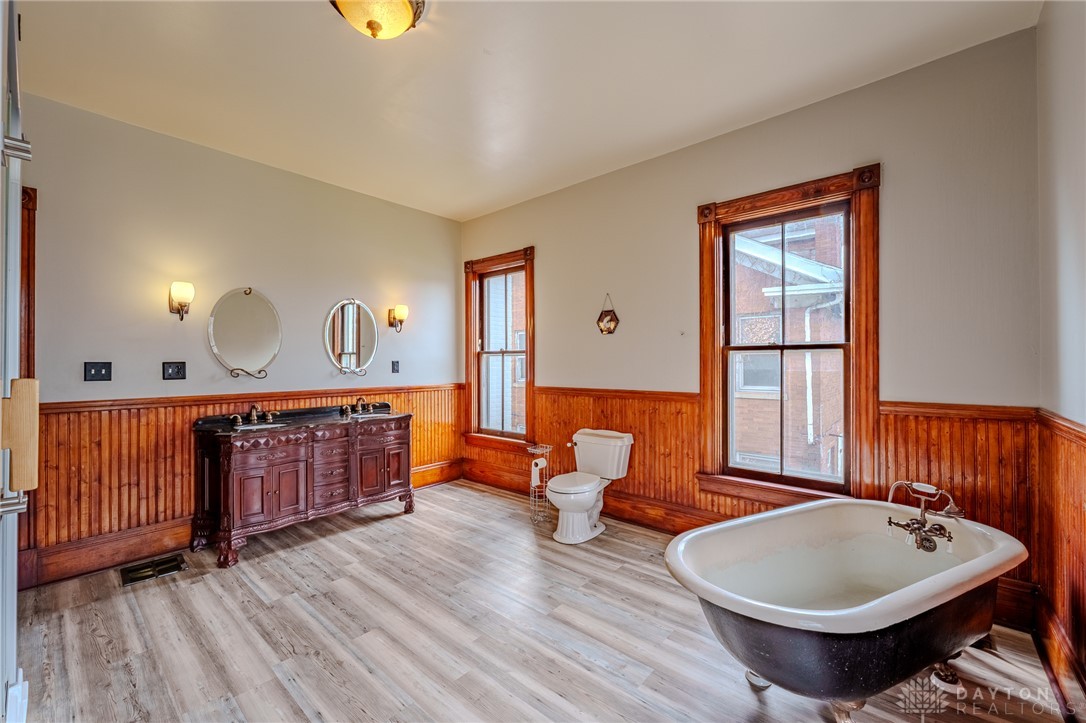 308 Yankee Road Middletown, OH 45044 - Photo 27 of 47 This spacious bathroom boasts a classic clawfoot tub, a double vanity, and elegant wood paneling.