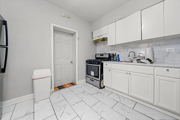 a kitchen with white cabinets and white appliances