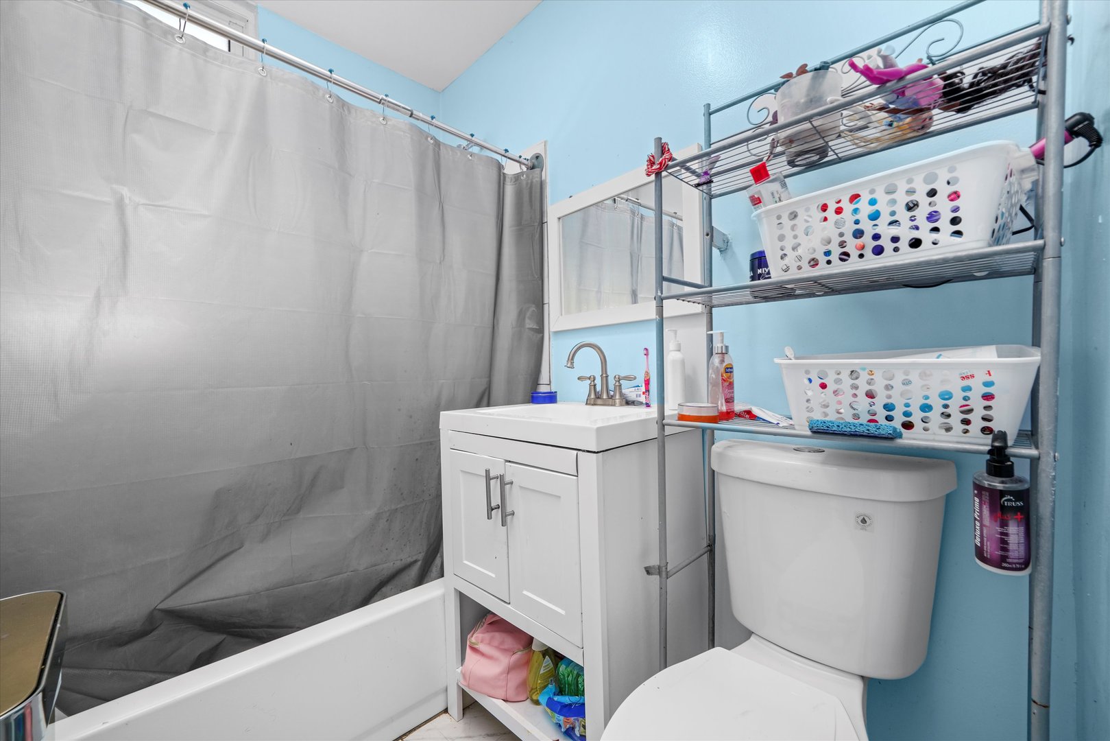 2016 East 93rd Street Chicago, IL 60617 - Photo 8 of 17 a bathroom with a sink a toilet and a shower curtain