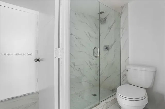 a bathroom with a toilet and a shower