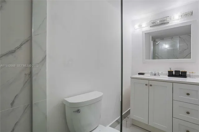a bathroom with a toilet a sink a mirror and vanity