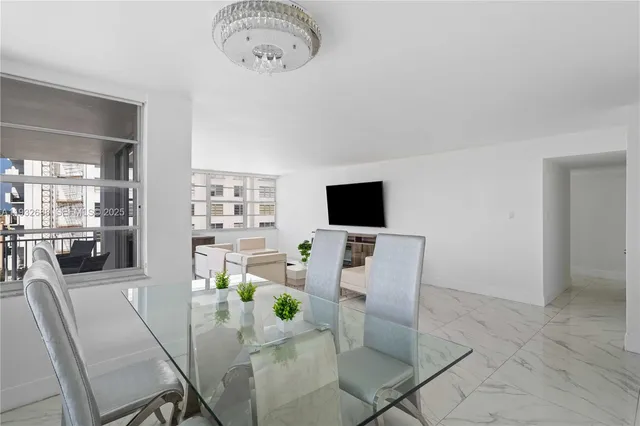 a living room with furniture a flat screen tv and kitchen view