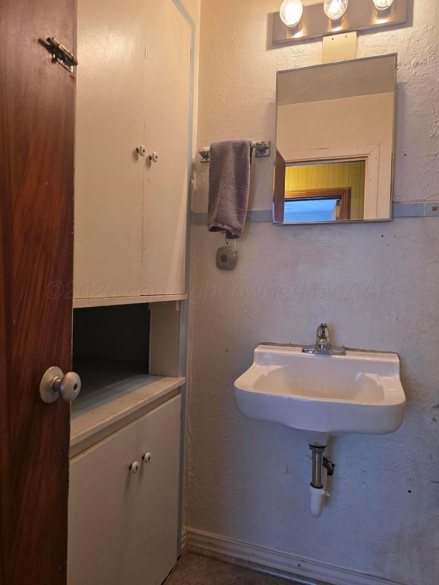 1812 Magnolia Street Amarillo, TX 79107 - Photo 17 of 27 a bathroom with a sink and a mirror