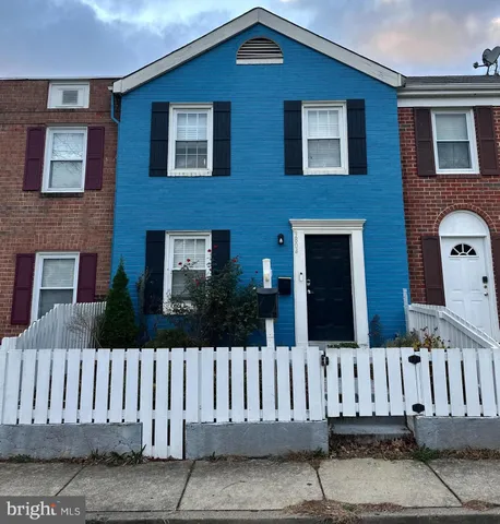 a view of a brick house with wooden fence