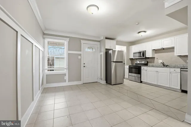 a kitchen with stainless steel appliances a refrigerator sink and microwave