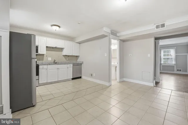 a view of kitchen with granite countertop cabinets and window
