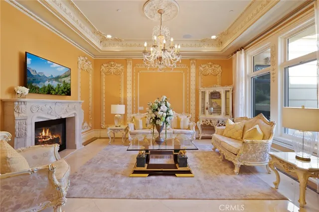 a living room with furniture fireplace and large windows