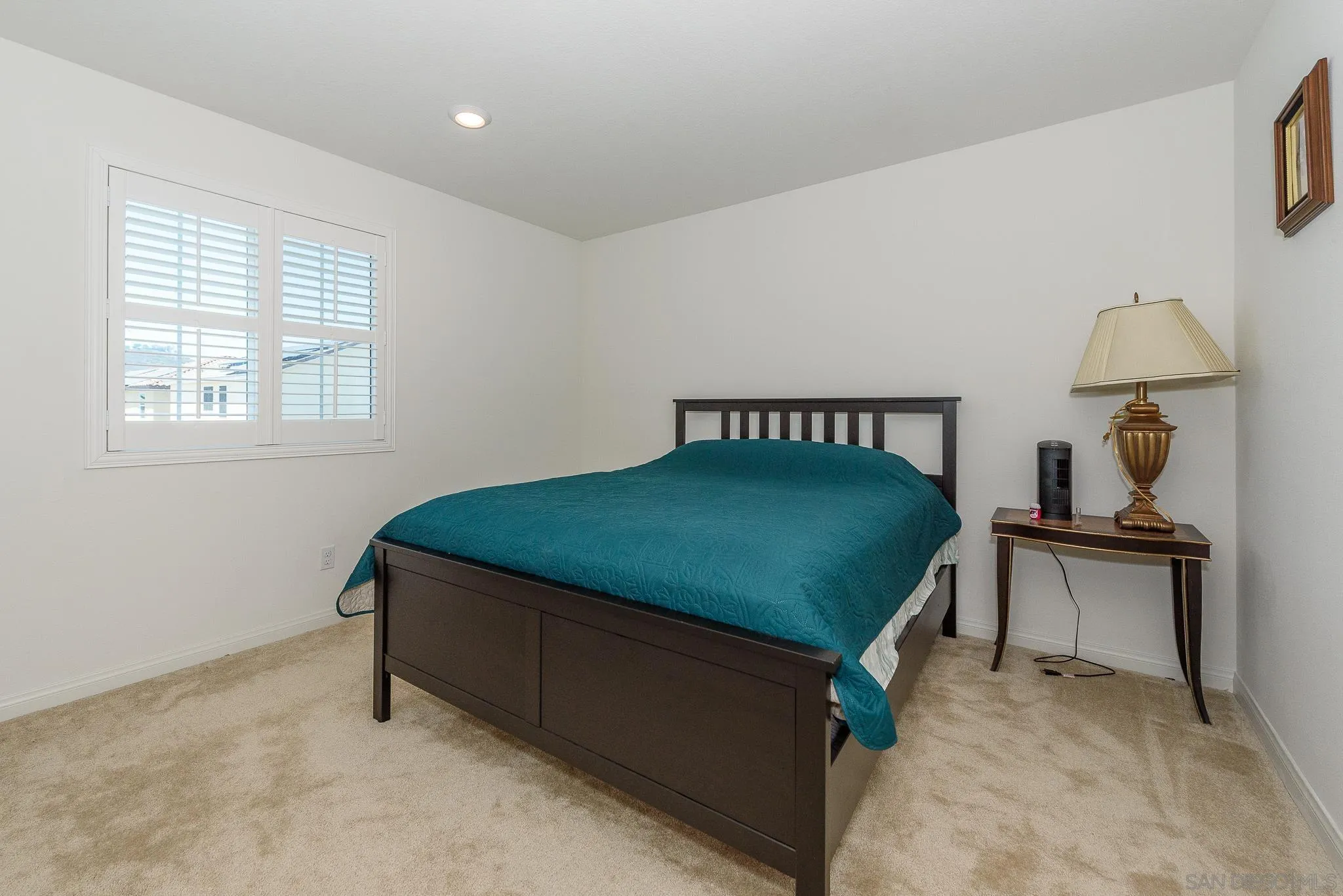 10761 Ensworth Way Spring Valley, CA 91978 - Photo 20 of 38 a bedroom with a bed a lamp and a window