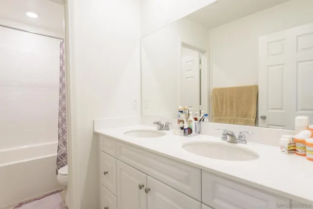 a bathroom with double sink and a mirror