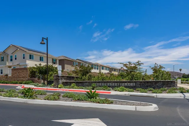 a view of a house with a big yard and potted plants