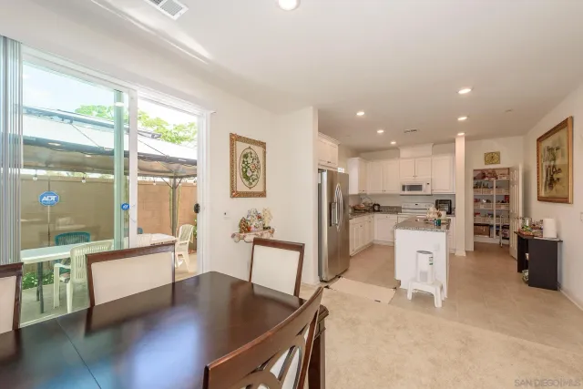a living room with dining table furniture wooden floor and a large window